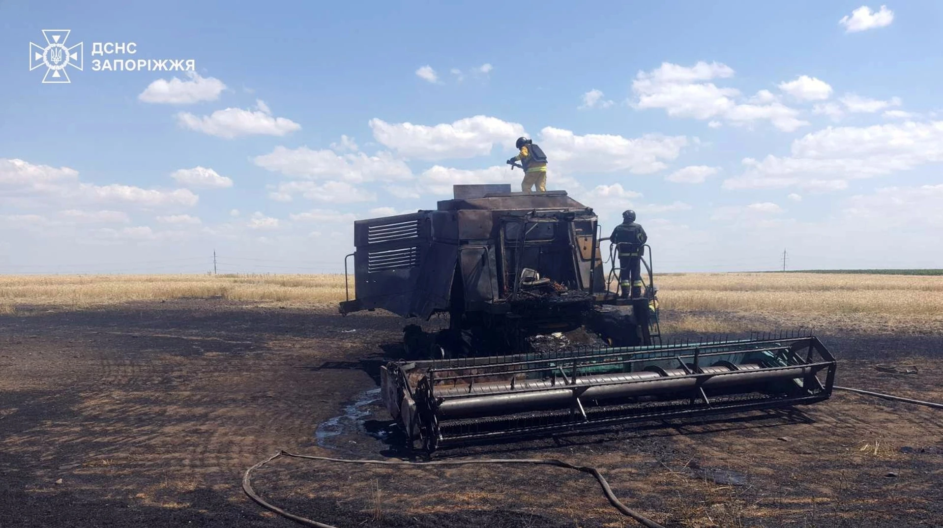 Сільськогосподарський комбайн у полі під час збирання врожаю, атакований FPV-дроном